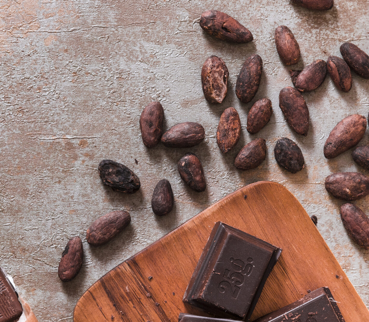 Blog chocolate bar pieces with cocoa beans rustic backdrop